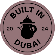 Round badge with a black teapot and sign saying "Built in Dubai"
